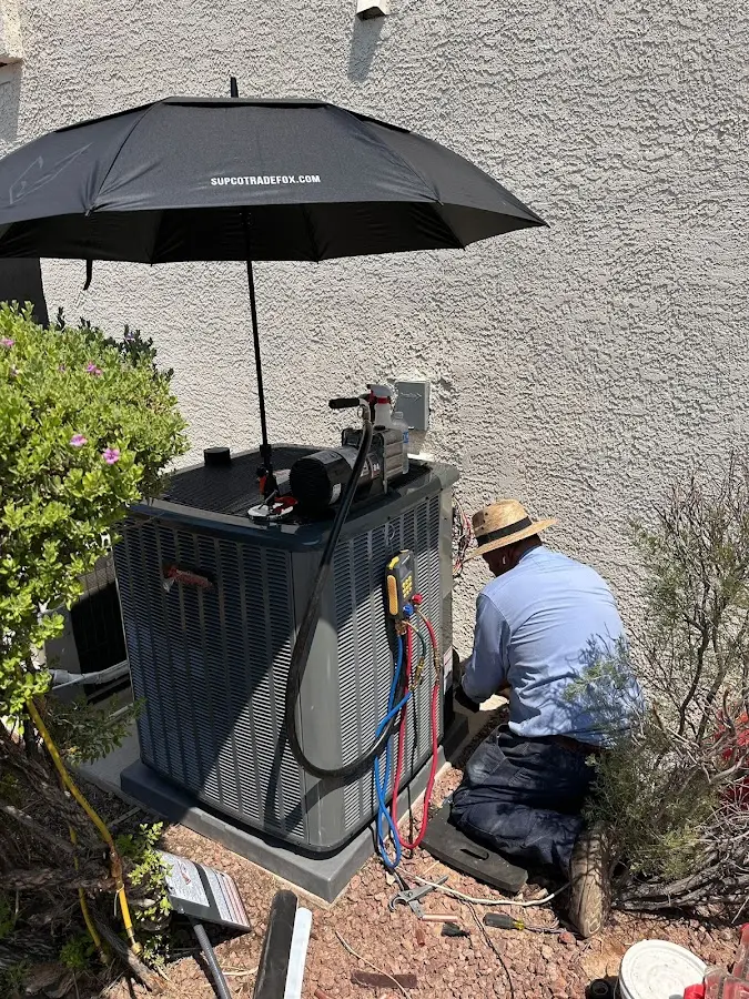 HVAC technician performing outdoor AC maintenance in Belterra